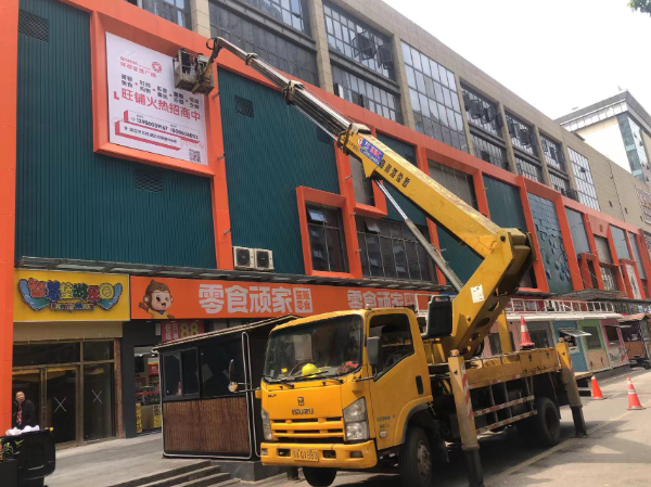 升降车安装商场招商广告牌施工现场
